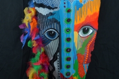 Head of State #11 blue stripe down face with black dots suggest a nose on colorful queen palm feathers attached fo left side of head
