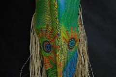 Head of State #13 greens, yellow and orange create a face on a narro queen palm straw hair lines sides