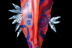 Head of State #15 Large eyes gaze out from queen palm painted in red and blue with decorative hair to the side