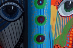 Head of State #11, detail arge eyes stare from vibrantly colored paterning on palm frond