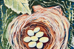 seven eggs in birds nest with green leaves in background