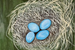 Four blue eggs nestled in center of traw like nest